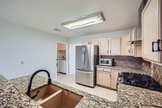 kitchen featuring stainless steel fridge, stove, backsplash, sink, and light tile patterned floors