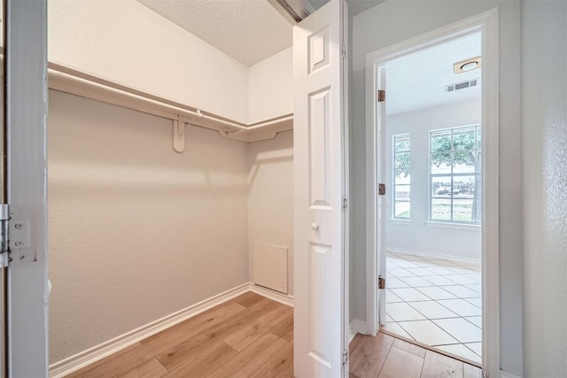 spacious closet with light hardwood / wood-style floors