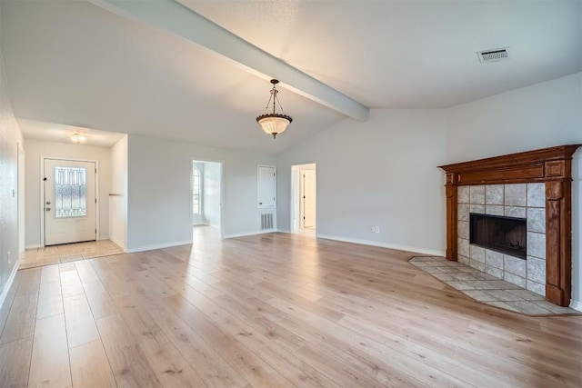 unfurnished living room with vaulted ceiling with beams, light hardwood / wood-style floors, and a fireplace