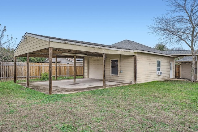 back of house featuring a lawn, cooling unit, and a garage