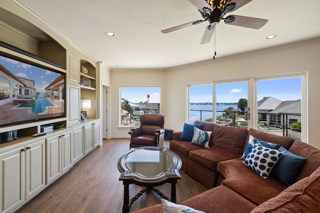 living room featuring ceiling fan, a water view, crown molding, and light hardwood / wood-style flooring