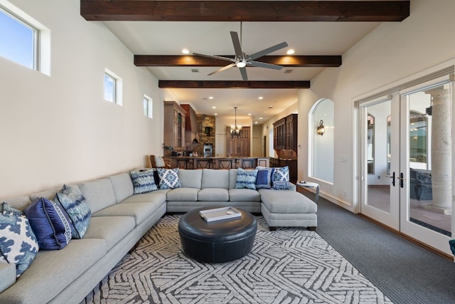 living room featuring ceiling fan with notable chandelier, beam ceiling, carpet floors, and french doors