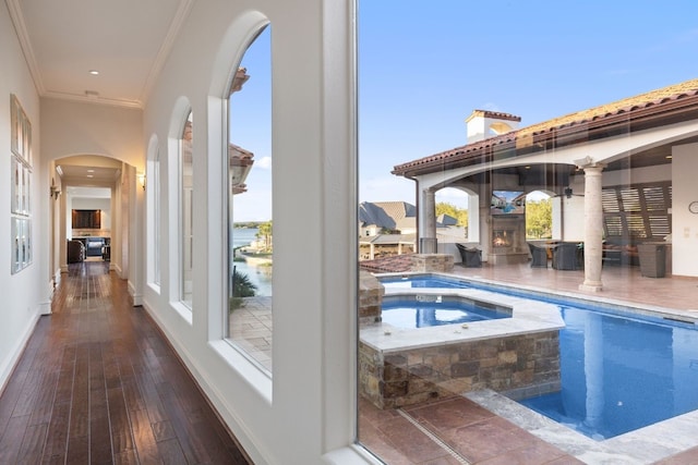 view of pool with a water view and an in ground hot tub