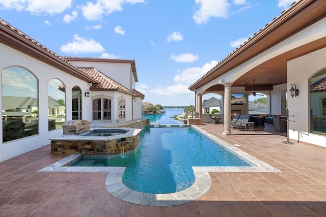 view of swimming pool featuring a patio area, an in ground hot tub, and a water view