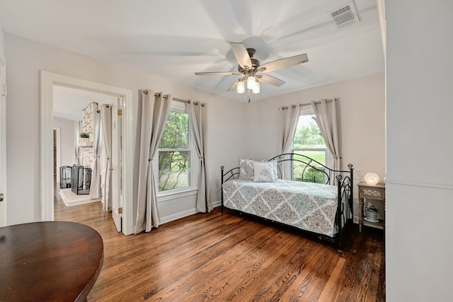 bedroom with multiple windows, ceiling fan, and dark wood-type flooring