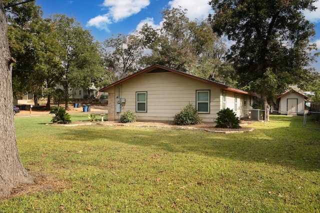 view of property exterior with central AC, a yard, and a shed