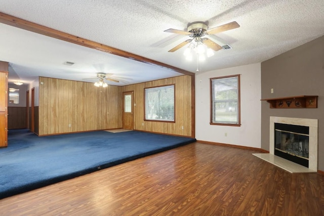 workout room with a textured ceiling, dark hardwood / wood-style floors, ceiling fan, and wood walls