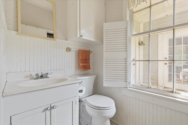 371 Youngs Prairie Rd, Elgin, TX 78621 - bathroom with wallpapered walls, toilet, vanity, and a wainscoted wall