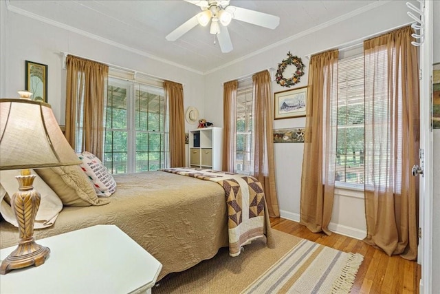 bedroom with ceiling fan, light hardwood / wood-style floors, and crown molding