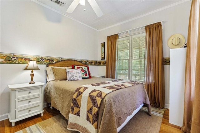 bedroom with ceiling fan, wood-type flooring, and ornamental molding