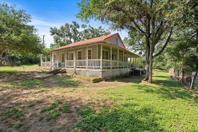 view of front of home with a front yard, a porch, and central AC