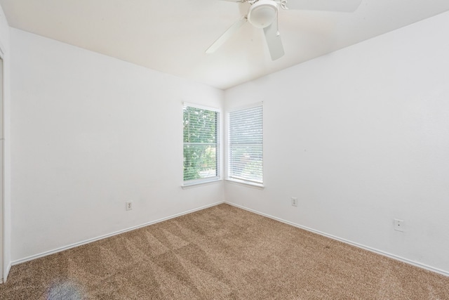 carpeted spare room with ceiling fan