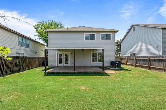 back of property with a yard, a patio, and french doors