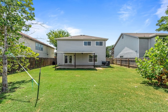 back of property with a lawn and a patio