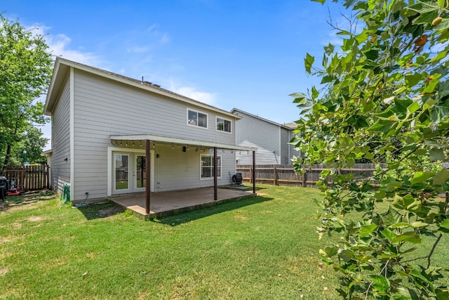 rear view of property featuring french doors, a patio, and a lawn