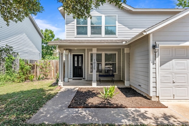 entrance to property with covered porch and a garage