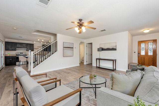 living room featuring ceiling fan and light hardwood / wood-style flooring