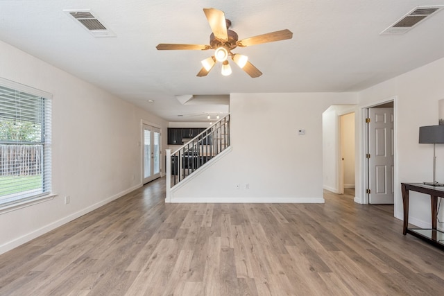 unfurnished living room with ceiling fan and wood-type flooring