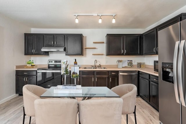 kitchen featuring a breakfast bar, sink, light hardwood / wood-style flooring, and appliances with stainless steel finishes