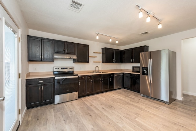 kitchen with sink, stainless steel appliances, and light wood-type flooring