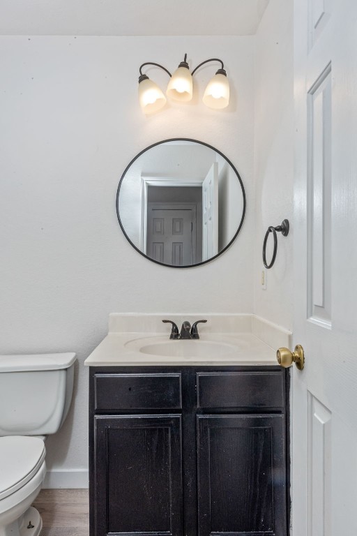 bathroom featuring vanity, wood-type flooring, and toilet