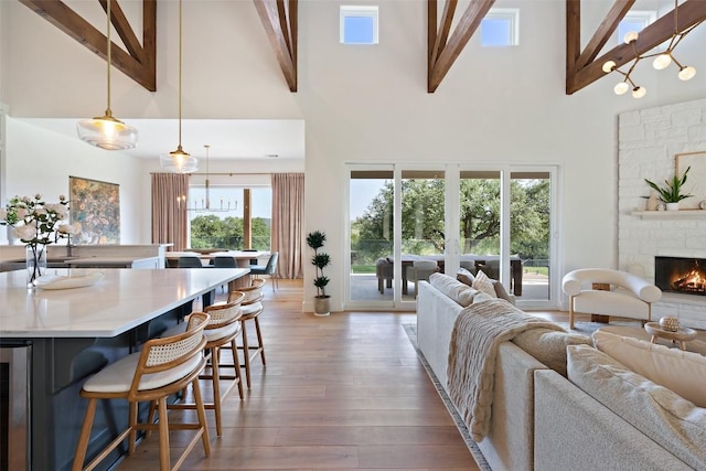 living room with a fireplace, beamed ceiling, high vaulted ceiling, and plenty of natural light