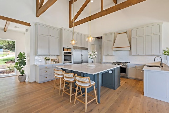 kitchen featuring custom exhaust hood, high end appliances, sink, a kitchen island, and beam ceiling