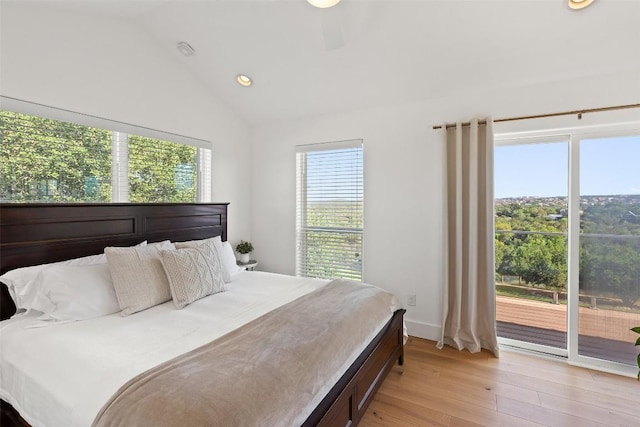 bedroom with vaulted ceiling, access to outside, and multiple windows