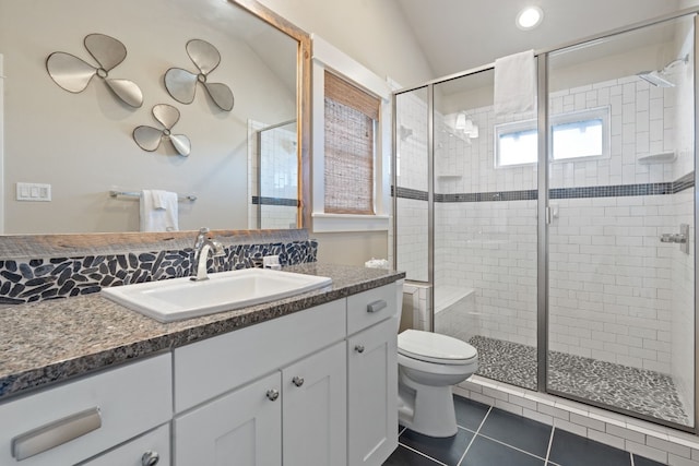 bathroom with tile patterned floors, vanity, a shower with door, toilet, and lofted ceiling