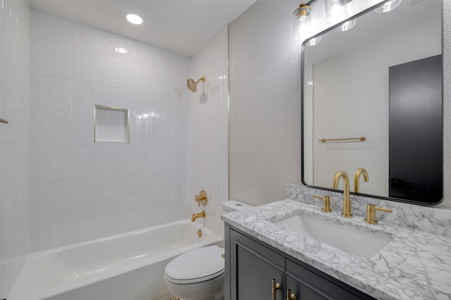 full bathroom featuring vanity, tiled shower / bath combo, and toilet