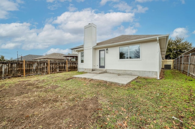 rear view of house with a yard, a patio, and central AC