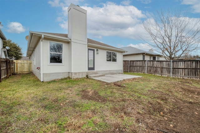 back of house with a patio area and a yard