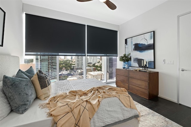 bedroom featuring ceiling fan, dark wood-type flooring, and multiple windows