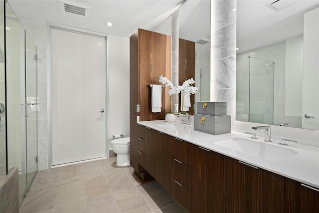 bathroom featuring tile patterned flooring, vanity, toilet, and a shower with shower door