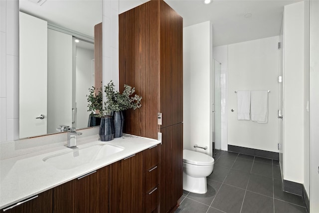 bathroom with tile patterned floors, a shower with door, vanity, and toilet