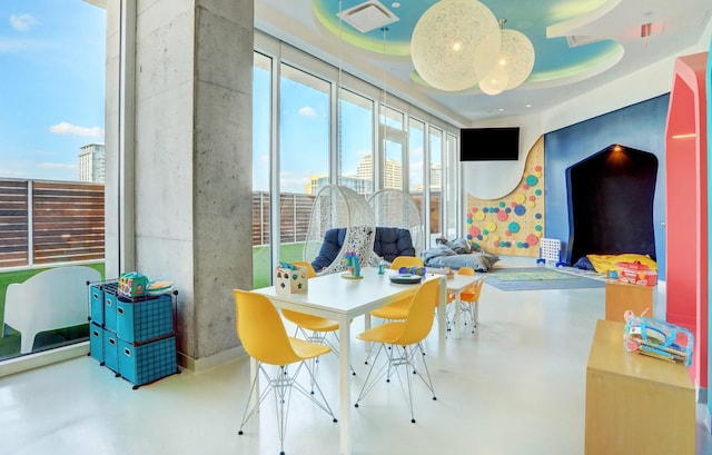 interior space with a tray ceiling and concrete flooring