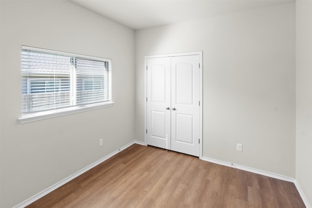 unfurnished bedroom with a closet and light wood-type flooring