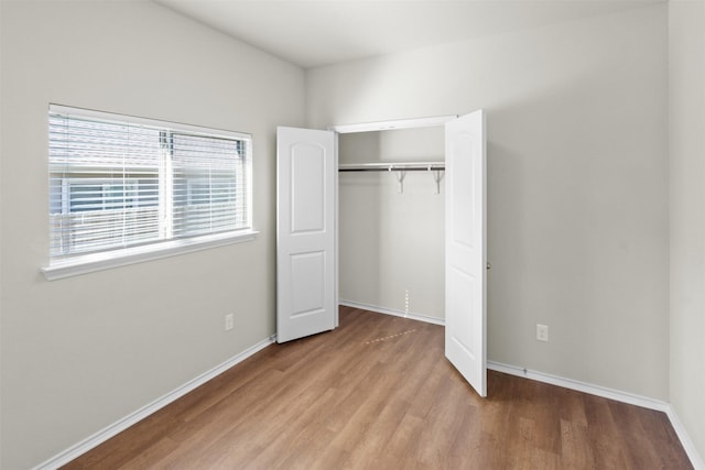 unfurnished bedroom with light hardwood / wood-style flooring and a closet