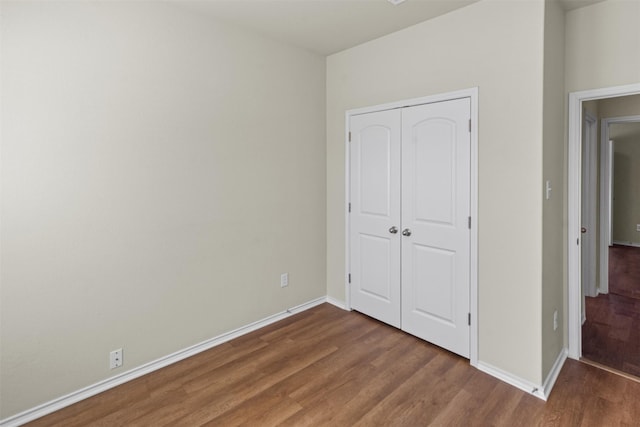 unfurnished bedroom featuring hardwood / wood-style floors and a closet