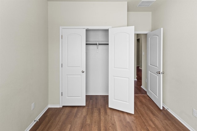 unfurnished bedroom with a closet and dark wood-type flooring