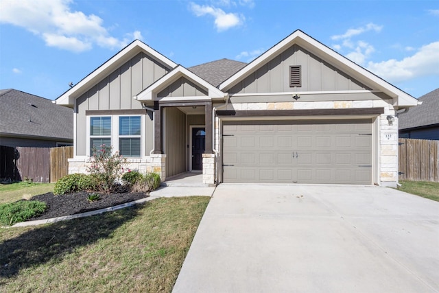 craftsman inspired home with a garage and a front lawn