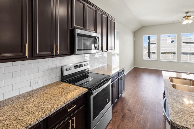 kitchen featuring dark brown cabinetry, decorative backsplash, stainless steel appliances, and lofted ceiling