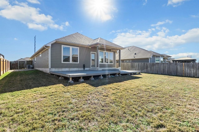 back of house with a wooden deck and a lawn