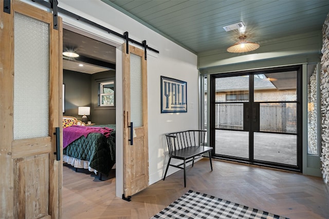 interior space with a barn door, parquet flooring, and wooden ceiling