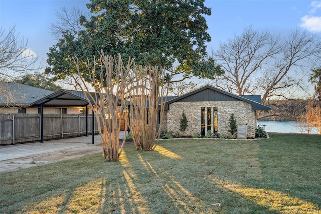 back of property with a water view and a yard