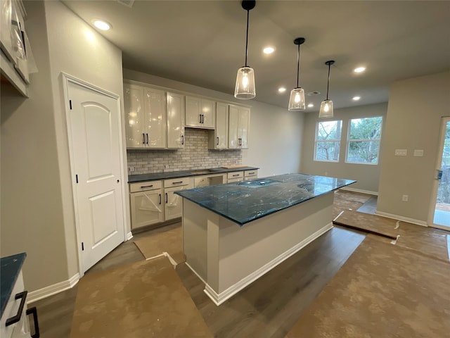 kitchen featuring a kitchen island, dark wood-type flooring, white cabinetry, tasteful backsplash, and hanging light fixtures