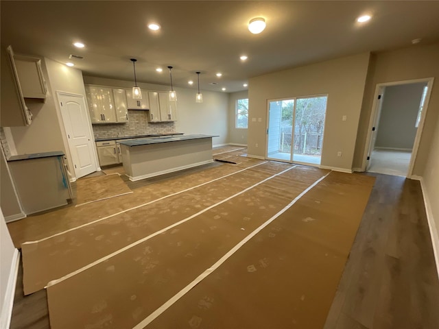 kitchen with white cabinetry, backsplash, pendant lighting, and a kitchen island