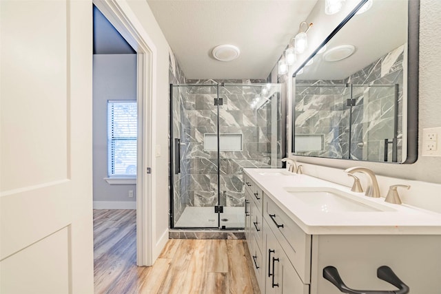 bathroom featuring wood-type flooring, vanity, a textured ceiling, and an enclosed shower