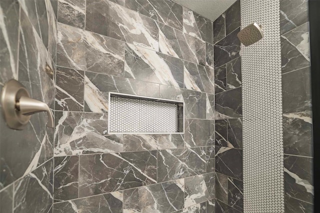 bathroom with a tile shower and a textured ceiling