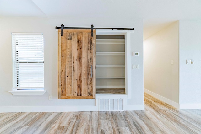 room details with hardwood / wood-style floors and a barn door